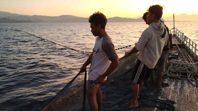 三名印尼渔民在近海捕鱼时撒网